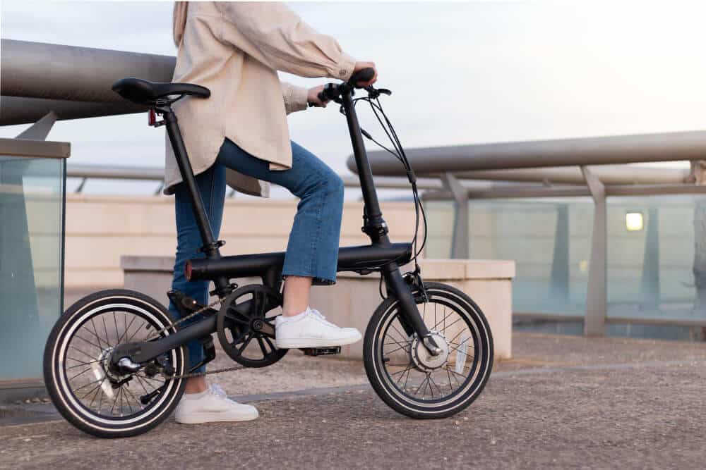zero emission concept cropped woman legs riding electric bicycle around city wearing casual outfit 1 1