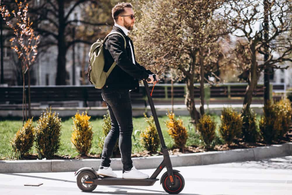 young handsome man riding scooter park 1 1